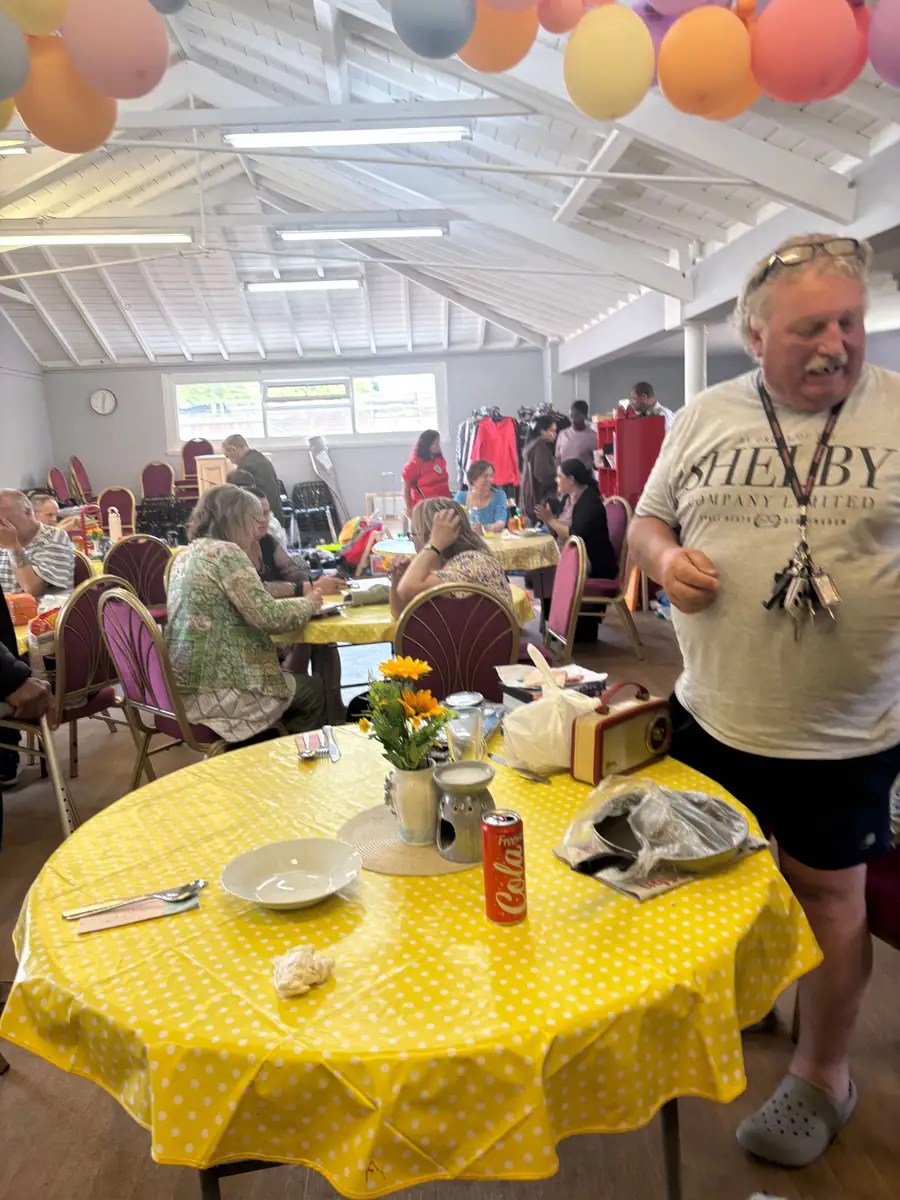 Guests at yellow tables under balloons during the Thursday Community Café at Full Gospel Tabernacle Birmingham